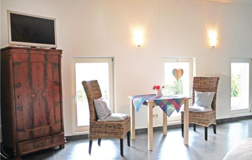 a dining room with a table and chairs and a television at Beautiful Apartment In Wingst in Wingst