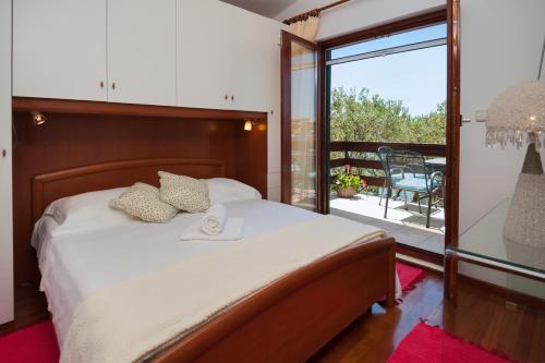 een slaapkamer met een bed en een balkon bij Villa Lucmar - swimming pool in Podglavica