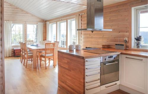 a kitchen with wooden walls and a table with chairs at Amazing Home In Hol With Sauna in Seim