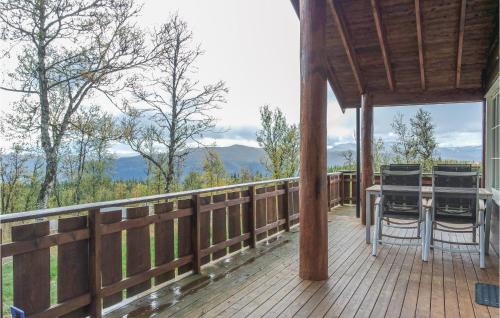 a wooden deck with a table and chairs on it at Amazing Home In Hol With Sauna in Seim