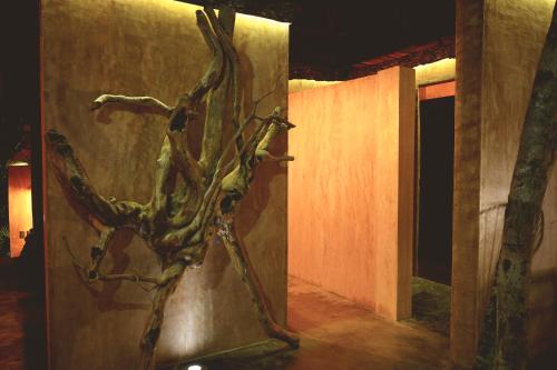 a metal sculpture of a tree on the side of a wall at Bufo Alvarius in Tulum