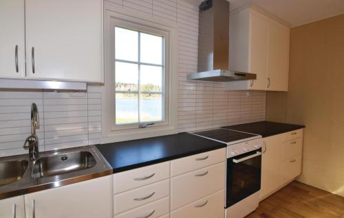 a kitchen with white cabinets and a sink and a window at Gorgeous Home In Svanskog With Wifi in Svanskog