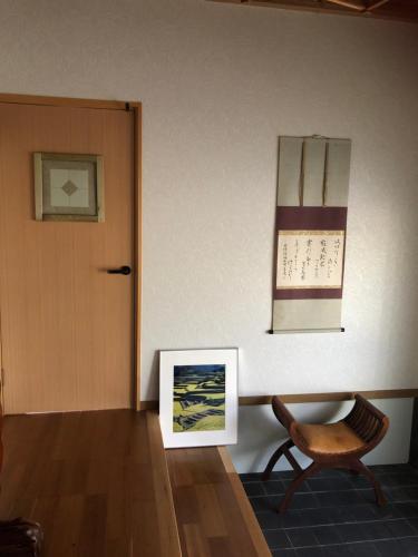 a room with a door and a chair and a calendar at familie in Otsu