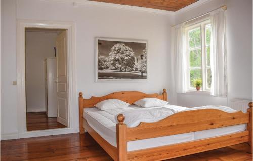 1 dormitorio con cama de madera y ventana en Amazing Home In Gullabo With Kitchen, en Gullabo