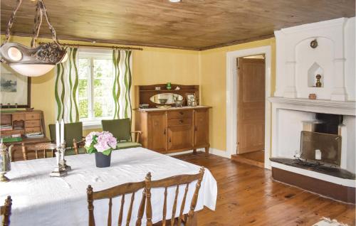 a dining room with a table and a fireplace at Holiday Home Rökulla Mariannelund in Mariannelund