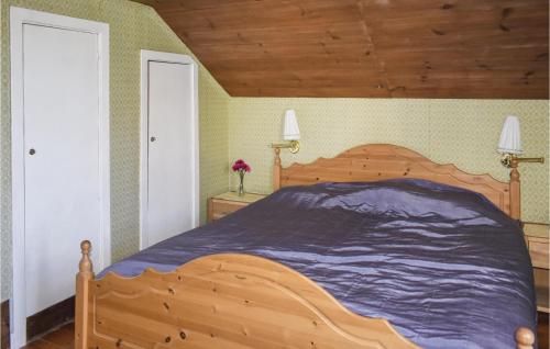 a bedroom with a large bed with a wooden headboard at Holiday Home Rökulla Mariannelund in Mariannelund