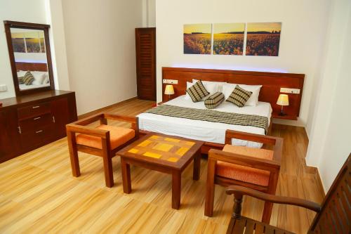 a bedroom with a bed and a table and chairs at Heaven in Satinwoods in Tangalle