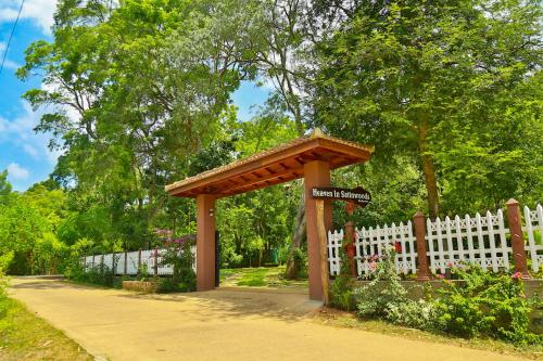 a wooden pavilion in front of a white fence at Heaven in Satinwoods in Tangalle
