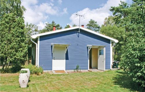 a blue house with a white door in a yard at Gorgeous Home In Färjestaden With Wifi in Färjestaden