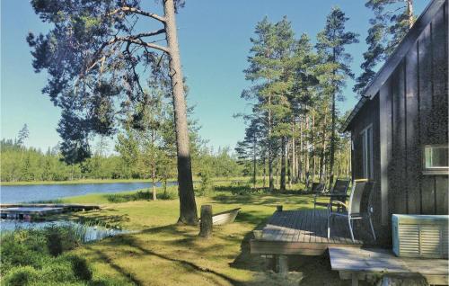 a house with a deck next to a lake at Lovely Home In Sandhem With Sauna in Sandhem