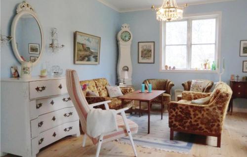 een woonkamer met een tafel en stoelen en een spiegel bij Lovely Home In Storebro With Kitchen in Storebro