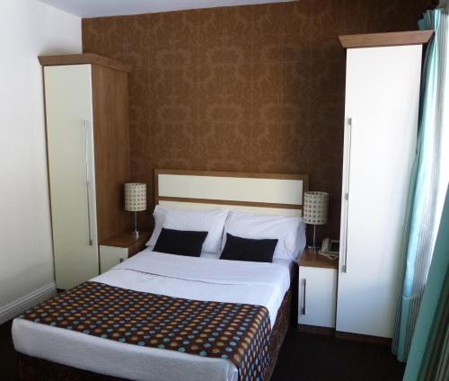 a bedroom with a bed with white sheets and pillows at The White Lady Hotel in Kinsale