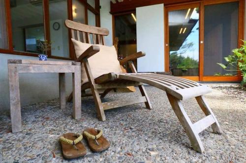 a wooden chair and a table and some shoes at Chang House in Zhuangwei