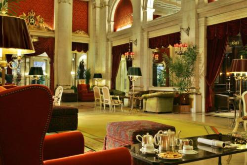 a lobby with a table and chairs in a building at Hotel Avenida Palace in Lisbon