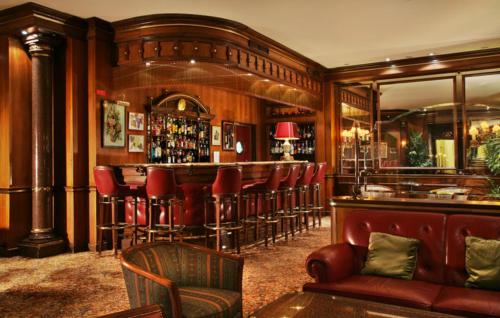a bar with red chairs and a red couch at Hotel Avenida Palace in Lisbon