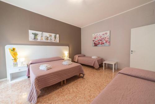 a bedroom with two beds and a table in it at B&B Siracusa Holidays in Syracuse