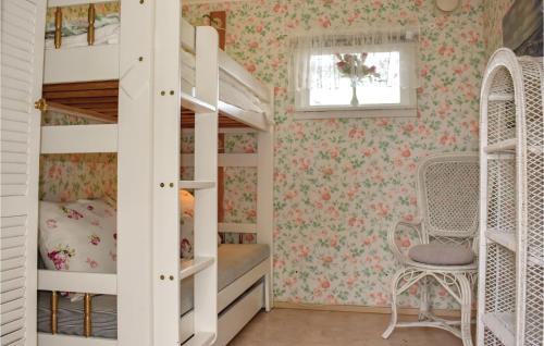Dormitorio infantil con literas y papel pintado con motivos florales en 3 Bedroom Awesome Home In Lttorp, en Löttorp