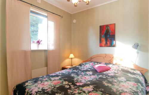 1 dormitorio con 1 cama con colcha de flores y ventana en Awesome Home In Visby With 2 Bedrooms And Wifi, en Nyhamn
