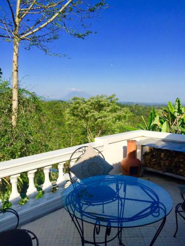 a patio with a table and chairs on a balcony at Pondok Plantation Luxury Mountain Escape Bedugul in Bedugul