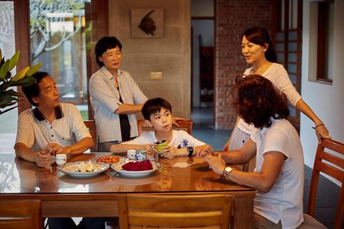 a group of people sitting around a table eating food at Chang House in Zhuangwei