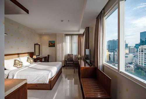 a hotel room with a bed and a large window at Aquari Hotel in Ho Chi Minh City