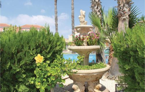 una fuente en un jardín con flores y plantas en 2 Bedroom Cozy Home In Orihuela Costa, en Orihuela Costa