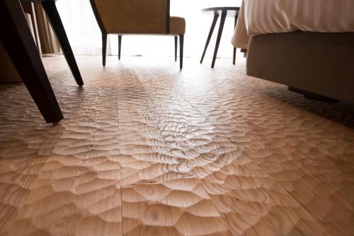 a room with a wooden floor with a table and chairs at Kamikochi Hotel Shirakabaso in Matsumoto