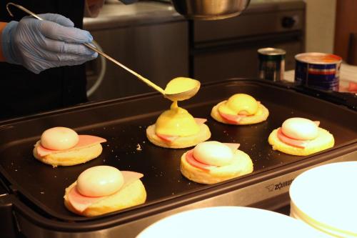 a person is preparing food on a pan with food on it at Kamikochi Hotel Shirakabaso in Matsumoto