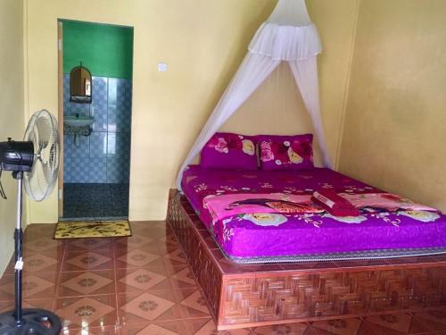 武吉拉旺的住宿－Sahnan Guest House，一间卧室配有一张带天蓬的床