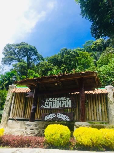 a building with a sign on the side of it at Sahnan Guest House in Bukit Lawang