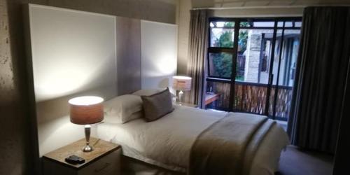 Un dormitorio con una cama grande y una ventana en Gold Crest Guesthouse en Roodepoort