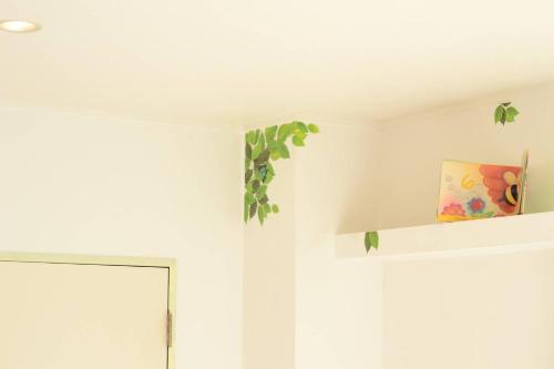 a room with a white wall and a shelf with a painting at Villa Del Mar Nosoko in Ishigaki Island