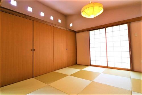 a room with wooden cabinets and a large window at Villa Del Mar Nosoko in Ishigaki Island