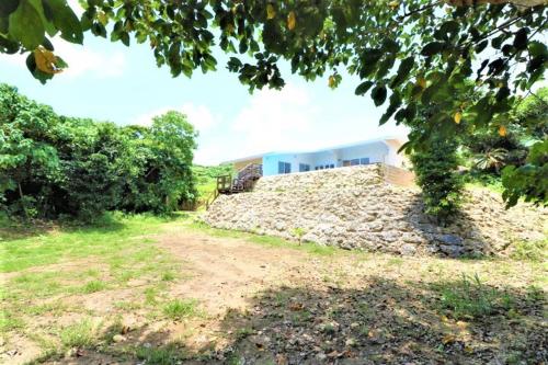 a stone wall in front of a house at Villa Del Mar Nosoko in Ishigaki Island