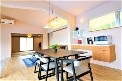 a kitchen and dining room with a table and chairs at Villa Del Mar Nosoko in Ishigaki Island