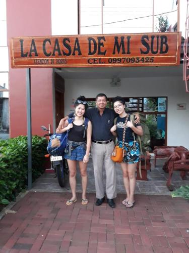 a man and two women standing in front of a store at La Casa De Mi Sub in Puerto Baquerizo Moreno