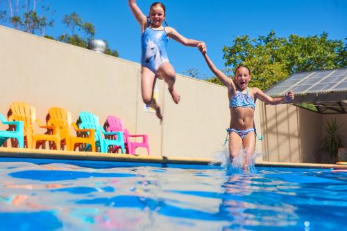 two children jumping into a swimming pool at BIG4 Swan Hill in Swan Hill