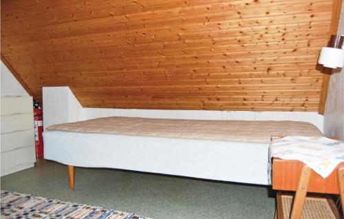 a bed in a room with a wooden ceiling at Holiday Home Loaklev Vetlanda Ii in Loaklev