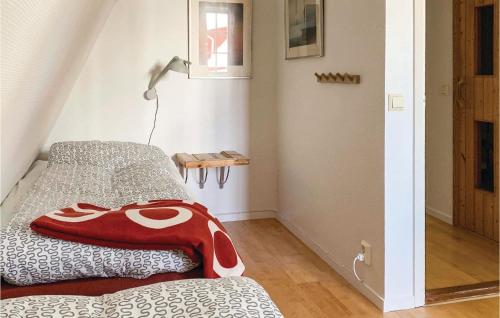 a bedroom with a bed with a red blanket on it at Holiday Home Vaggeryd 61 With Sauna in Hok