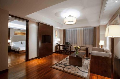 a hotel room with a bed and a living room at Ramada Plaza by Wyndham Xi'an South in Xi'an
