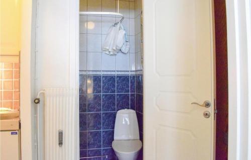 a bathroom with a toilet and a blue tiled wall at Amazing Apartment In Ystad With Kitchen in Ystad