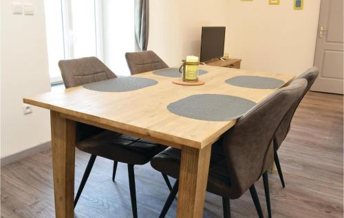 - une table en bois entourée de chaises dans l'établissement 1 Bedroom Cozy Apartment In Sainteny, à Sainteny