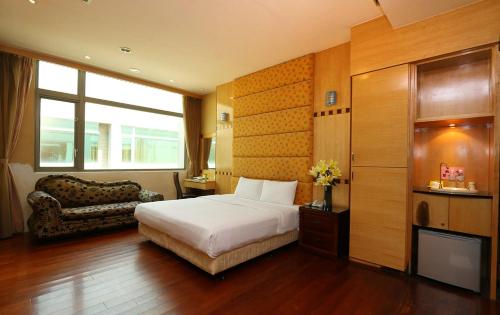 une chambre d'hôtel avec un lit et un canapé dans l'établissement Charming Motel, à Hualien