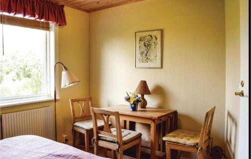 a room with a table and chairs and a bed at 2 Bedroom Lovely Home In Degerhamn in Gammalsby