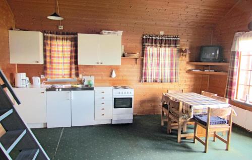 una cucina con tavolo, mobili bianchi, tavolo e sedie di 3 Bedroom Gorgeous Home In Bjoa a Haugsgjerd
