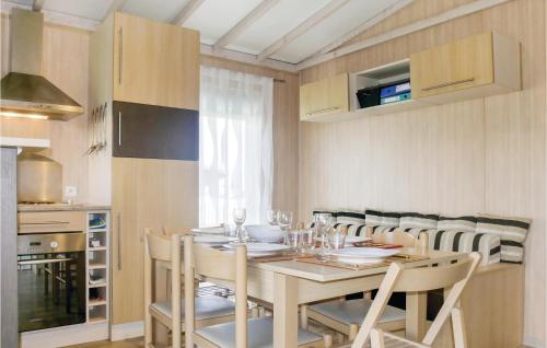 a dining room with a table and chairs and a kitchen at Nice Home In Grandcamp Maisy With Wifi in Grandcamp-Maisy