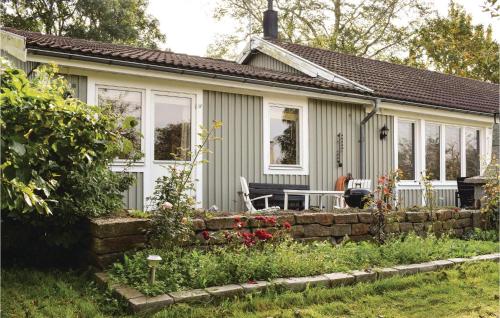 a small house with a stone wall in front of it at 2 Bedroom Lovely Home In Degerhamn in Gammalsby