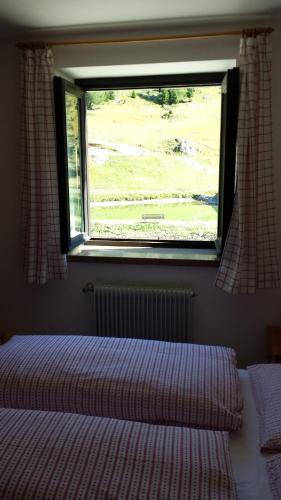 a bedroom with a bed and a window at Hotel Garni Gonzaga in Canazei