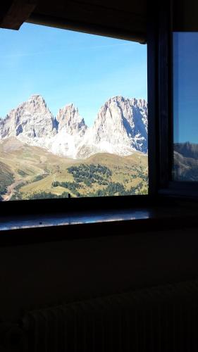 a view of a mountain range from a window at Hotel Garni Gonzaga in Canazei