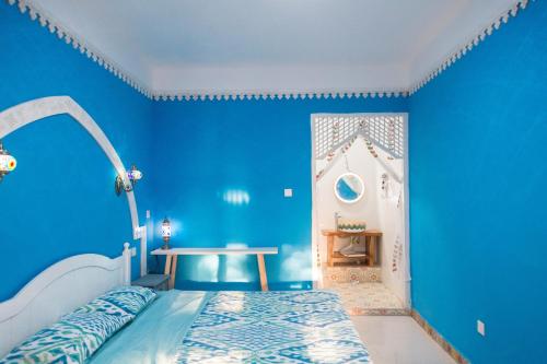 a blue bedroom with a bed and a blue wall at New Dap Hostel (in Grape Town) in Turfan